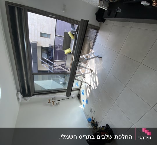 תריסים פתוחים ליד חלון זכוכית גדול
